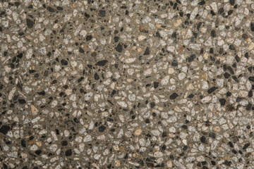 Gros plan texture béton désactivé avec graviers gris, noir et couleur