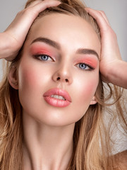 Portrait of a beautiful woman with a coral color makeup. Attractive blond  girl with  bright...