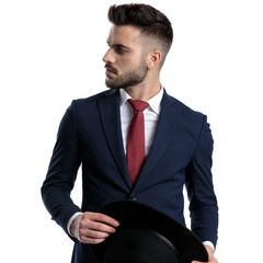 Thoughtful businessman holding his hat and looking to the side
