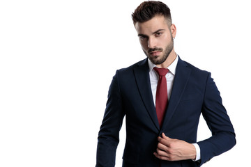 Charming young businessman unbuttoning his jacket