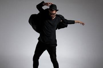 casual man wearing hat and glasses dancing with passion