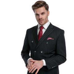 elegant young businessman wearing double breasted suit and red tie
