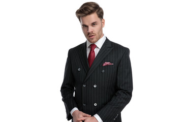 attractive young businessman wearing double breasted suit and red tie