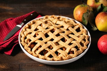 Homemade apple pie with lattice crust top on a rustic wooden table
