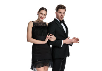 Elegant couple posing while she is holding his arm,