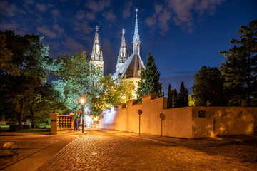 Fototapeta premium Church of St. Peter and Paul on Vysehrad. Cobbled street by night. Prague, Czech Republic