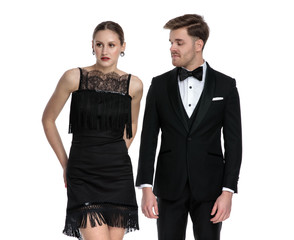 Unimpressed boyfriend wearing a tuxedo looking at his girlfriend