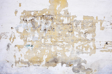 Broken white stucco on the wall. Abstract grunge background.