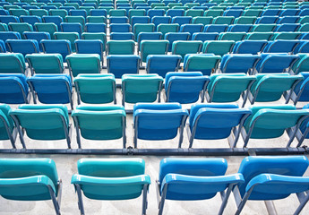 Perspective view of of folded blue chairs or seats in stadium