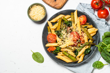 Vegan pasta penne with spinach, asparagus and tomato.