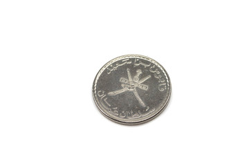A macro image of a silver coin from Oman, shot close up, against a white background