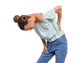 Portrait of unhappy teen girl suffering from backache, isolated on white background. Upset child massaging back suffering from discomfort ache pain. Cute young teenager hands touching back pain.