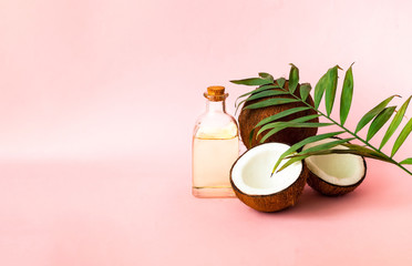 Coconut with coconut oil on pink background. Copy space