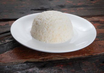 Fototapeta na wymiar Jasmine steamed rice on the white plate isolated on rustic wooden kitchen table
