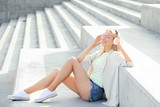 Beautiful young woman listening to music outdoors