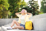 Beautiful young woman listening to music outdoors