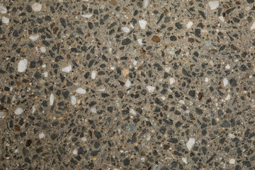 Gros plan texture béton désactivé avec graviers gris, noir et couleur
