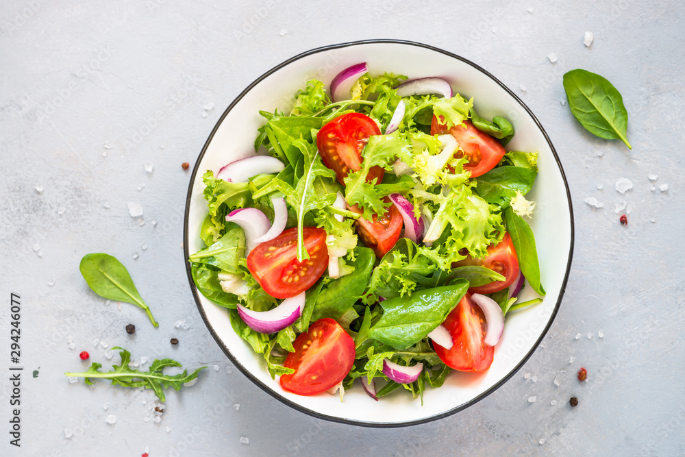 Poster Green salad from fresh leaves and tomatoes.