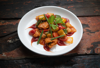 Top view Thai food chicken in sweet and sour sauceisolated on rustic wooden table