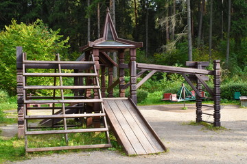Fototapeta na wymiar Children's play area in the park. Game sports structures made of natural wood in the yard