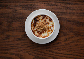Top view of traditional tukish rice pudding with walnut isolated on rustic wooden table