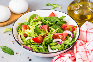 Green salad from fresh leaves and tomatoes.