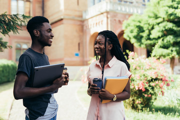 African male and female college students talking on campus