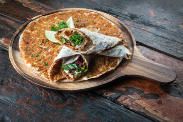 Lahmacun traditional Turkish pizza and wraps with salad isolated on rustic wooden table