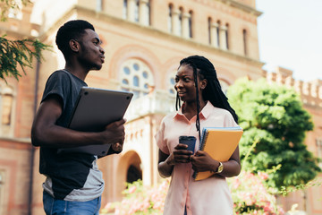 African male and female college students talking on campus