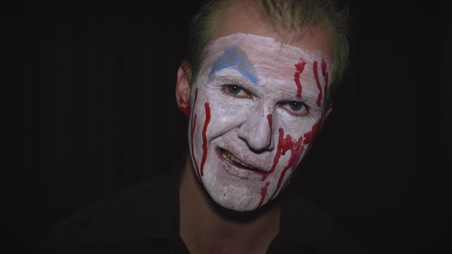 Clown Halloween man portrait. Creepy, evil clowns blood face. White face makeup