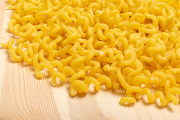 Raw yellow cavatappi pasta on wood table background