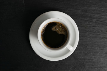 Obraz na płótnie Canvas Hot coffee cup on black stone background top view