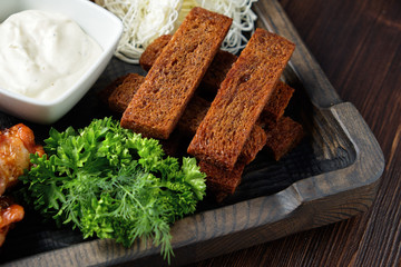 Hot appetizer on a wooden black plate on a dark wooden background. Restaurant menu
