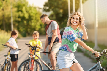 Woman and her family riding bicycles outdoors