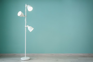 Fototapeta na wymiar Modern lamp near color wall