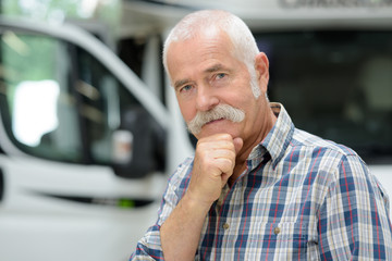 middle aged man posing in front of camping van