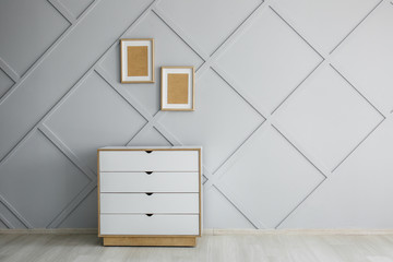 Chest of drawers near grey wall in room