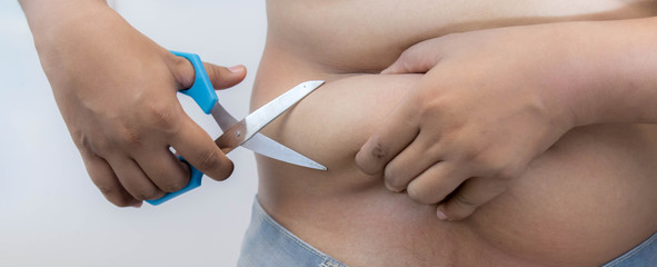 Overweight Asian obese men, He is feeling ill and worried about his excess weight. He squeezed his belly, showing the excess fat that was isolated on a white background