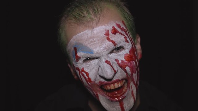 Clown Halloween man portrait. Creepy, evil clowns blood face. White face makeup