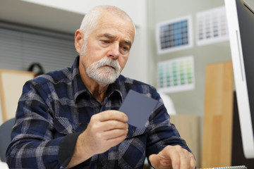 senior man is doing paperwork in her stock factory