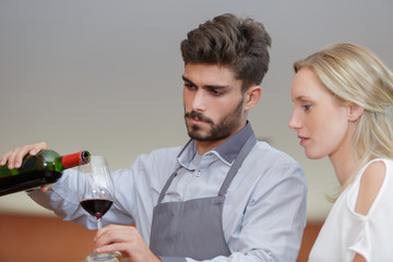 handsome sommelier looking at wine glass