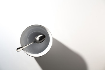Empty White Cereal or Soup Bowl with a Silver Spoon on a White Background