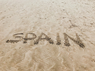 on the sandy beach in the sand the inscription spain is written 1