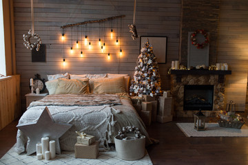 Cosy bedroom with eco decor. Wood and nature concept in interior of room. Scandinavian interior with christmas tree, real photo. Hygge decoration. Christmas concept.