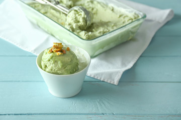Bowl with tasty pistachio ice cream on table