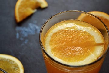 Freshly squeezed orange juice.  Orange and orange juice on a dark background. 