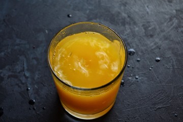 Freshly squeezed orange juice.  Orange and orange juice on a dark background. 