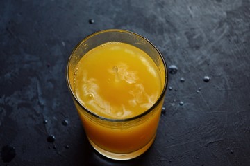 Freshly squeezed orange juice.  Orange and orange juice on a dark background. 