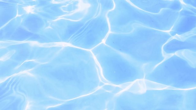 Footage of close up surface of blue clear rippling water in pool with bright sunlight leaks in summer. Relaxation leisure resort vacation concept