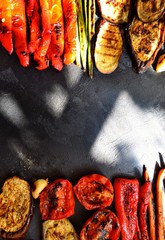 Grilled vegetables on a wooden board. Appetizing grilled vegetables in on a dark background,...